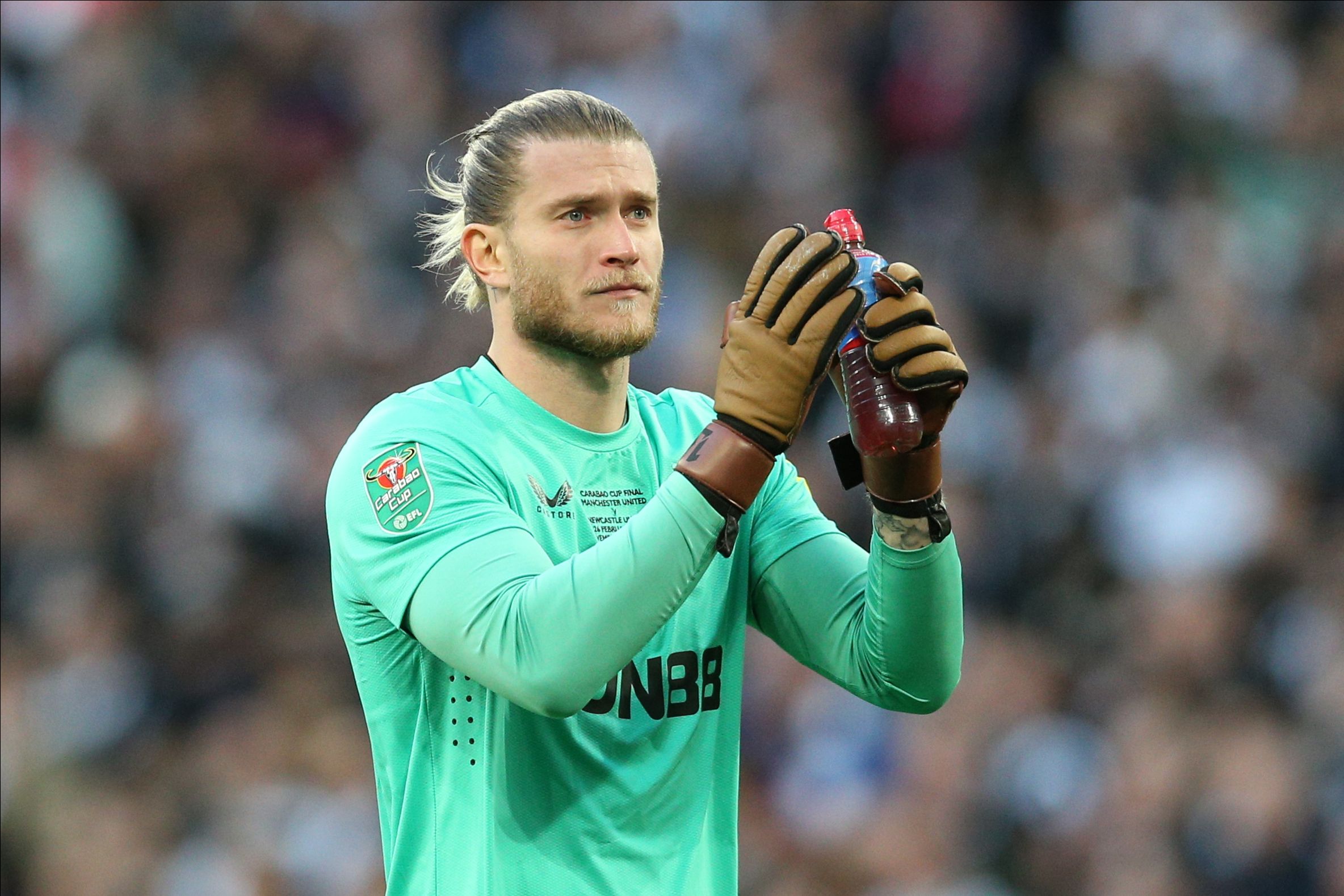 Loris Karius wearing a turquoise shirt and brown gloves clapping the Newcastle fans after the 2023 Carabao Cup Final (Goalkeeper.com)