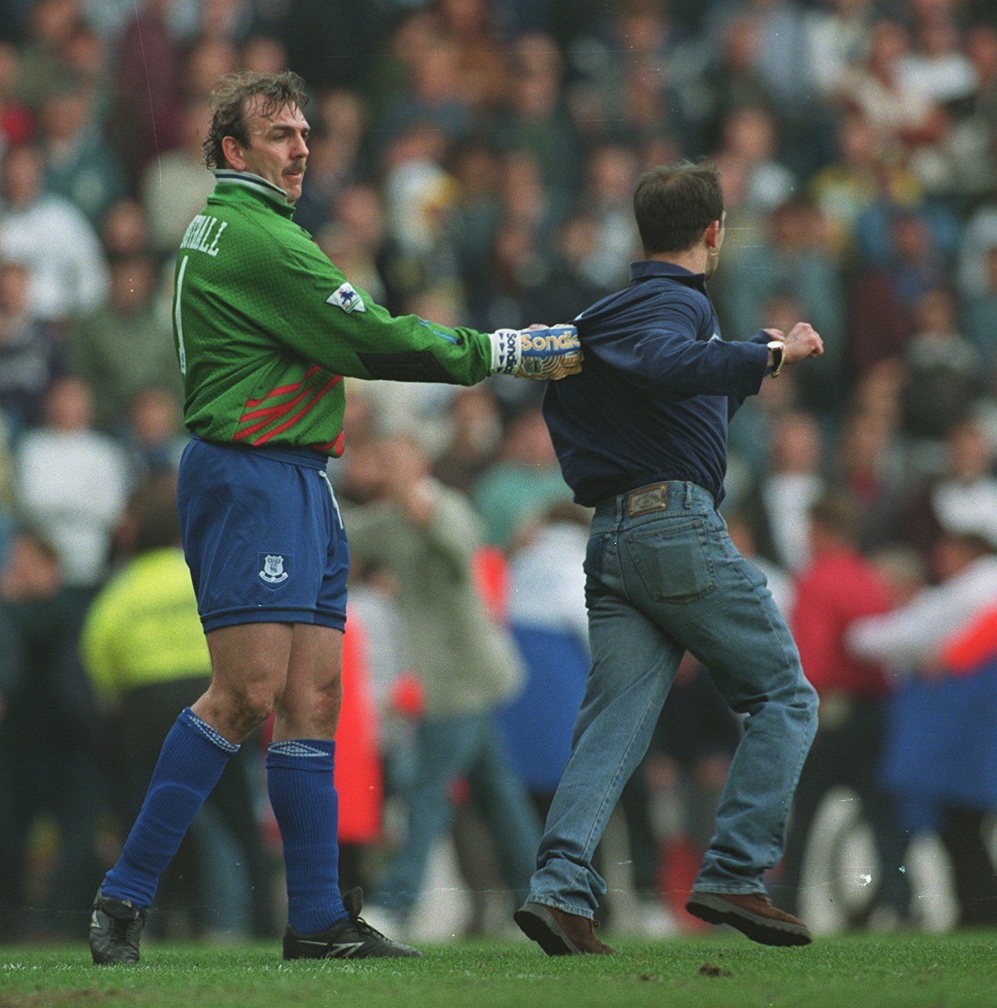 Neville Southall grabs a pitch invader in a game between Everton and Spurs (Goalkeeper.com)