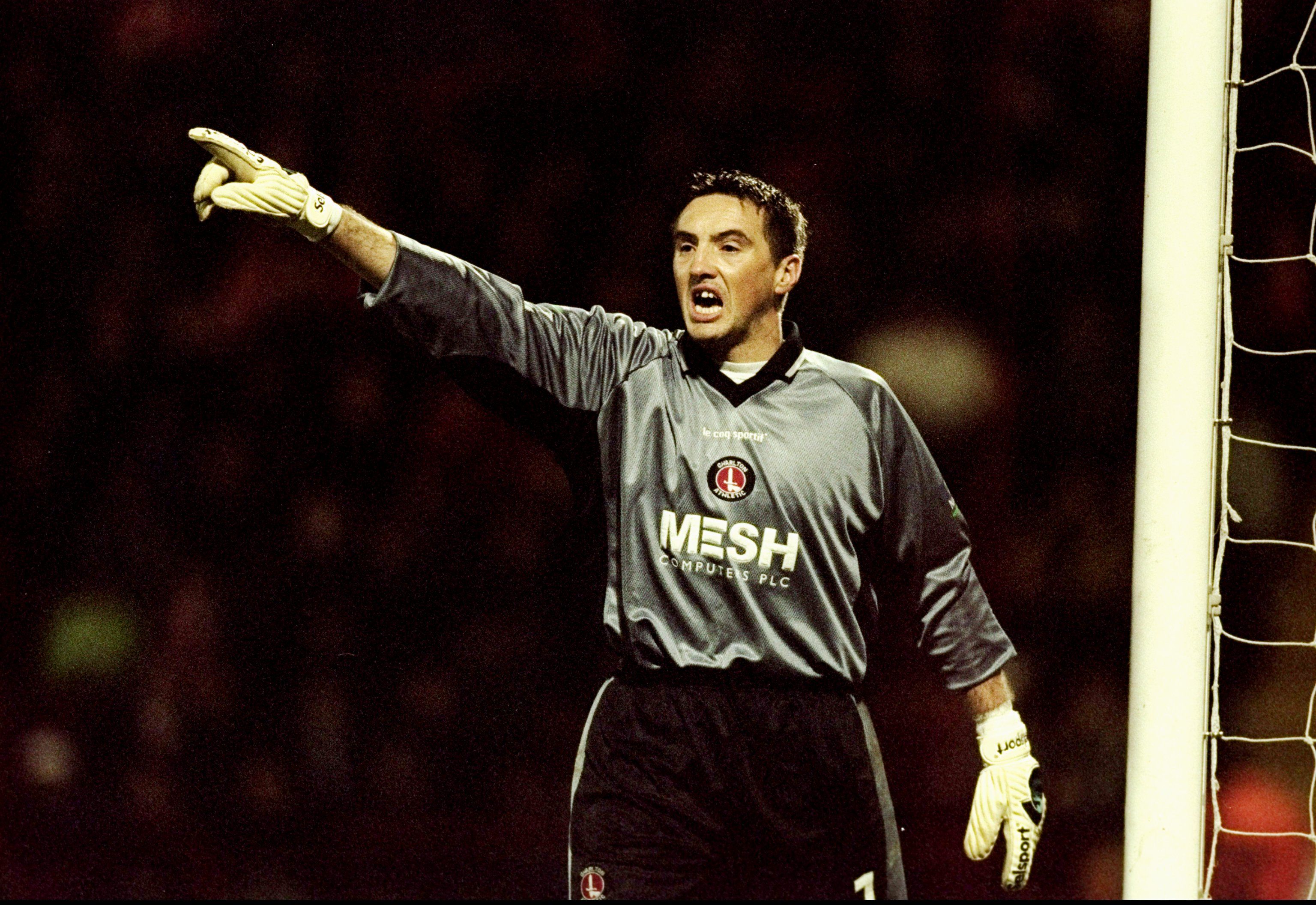 dean kiely wearing a charlton shirt points to his right