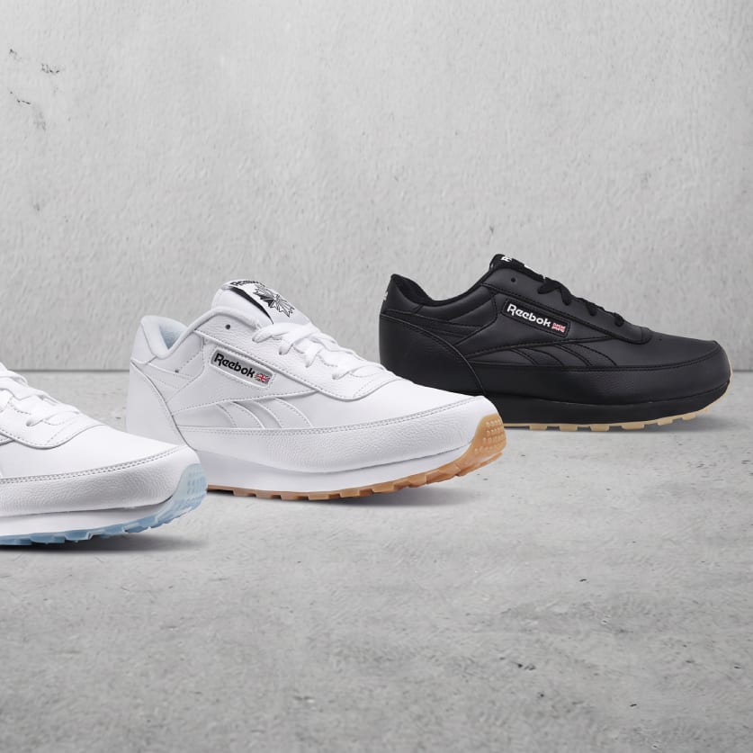 White and black Reebok Classic leather sneakers on a concrete floor