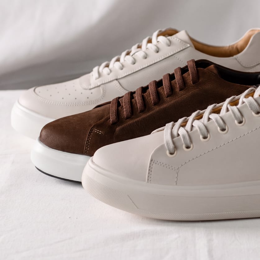 White, cream and brown suede leather sneakers on white fabric