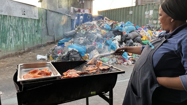Street vendor Emihle Phoswa braais pork chops and chicken wings near garbage in Dunoon.
© Peter Luhanga