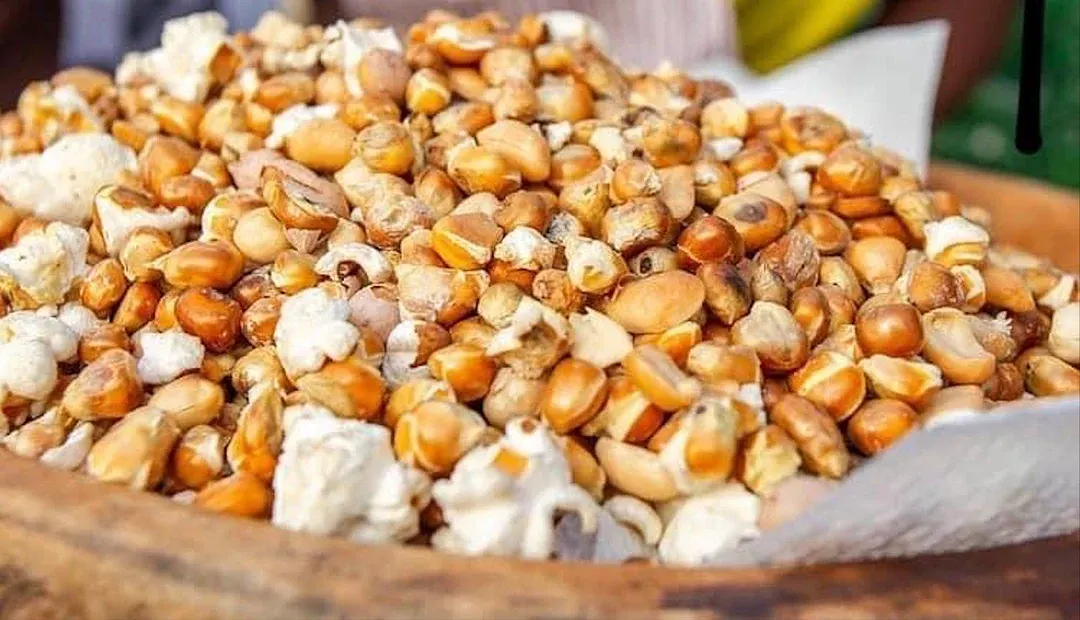 A street vendor carrying roasted corn and groundnuts
