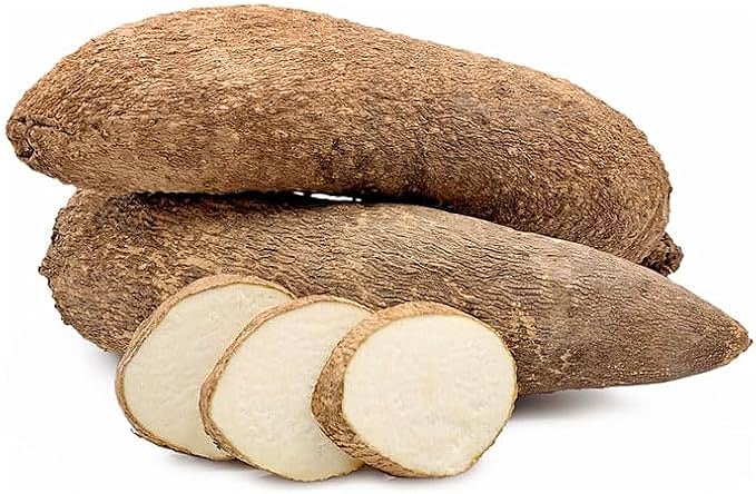 A Ghanaian market seller with whole yam tubers