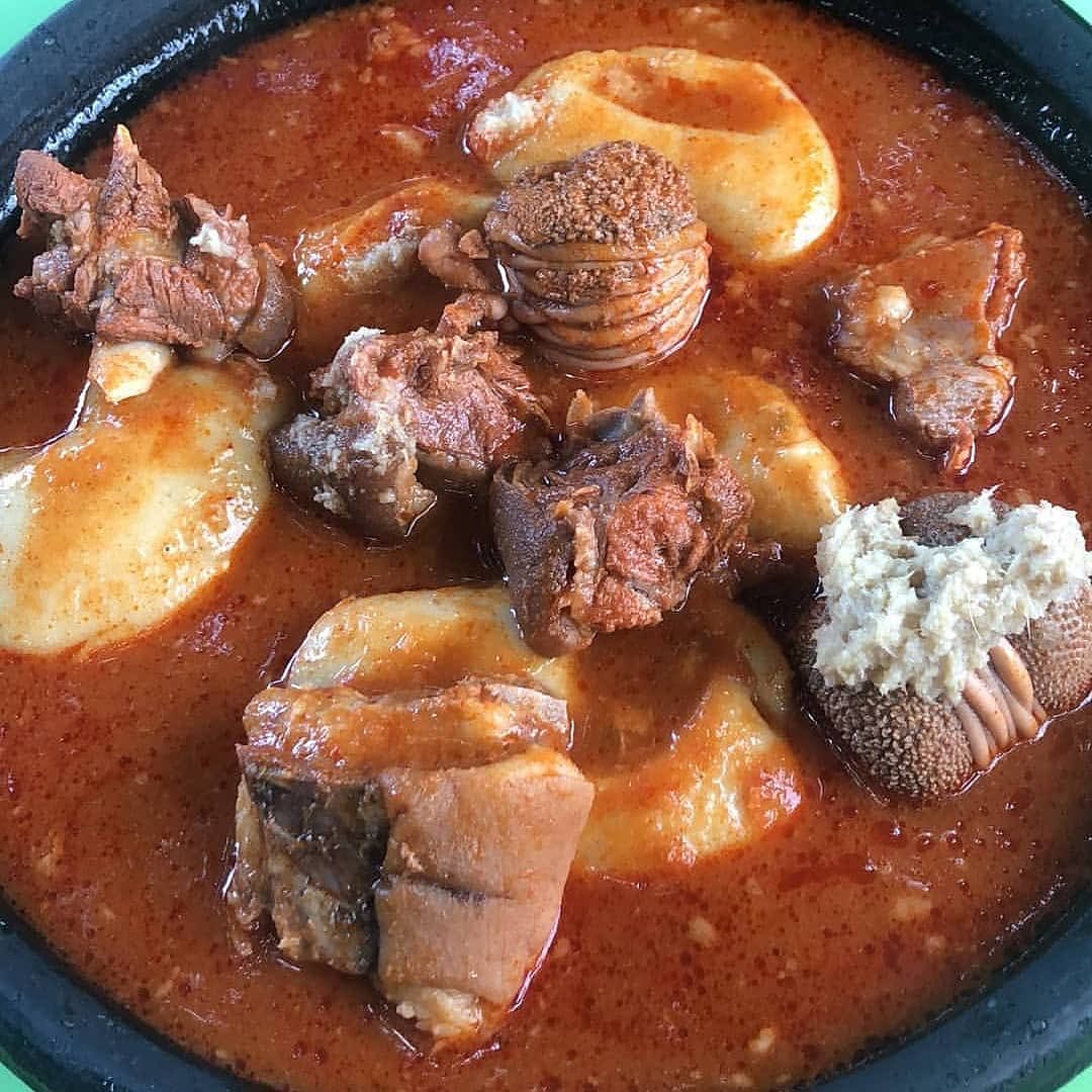 Fufu in Ghanaian palm nut soup with snail and tilapia