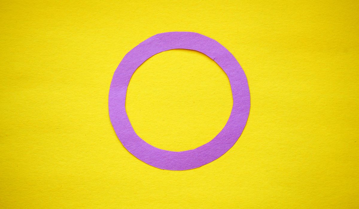 A purple paper ring on a yellow background that means Intersex.
