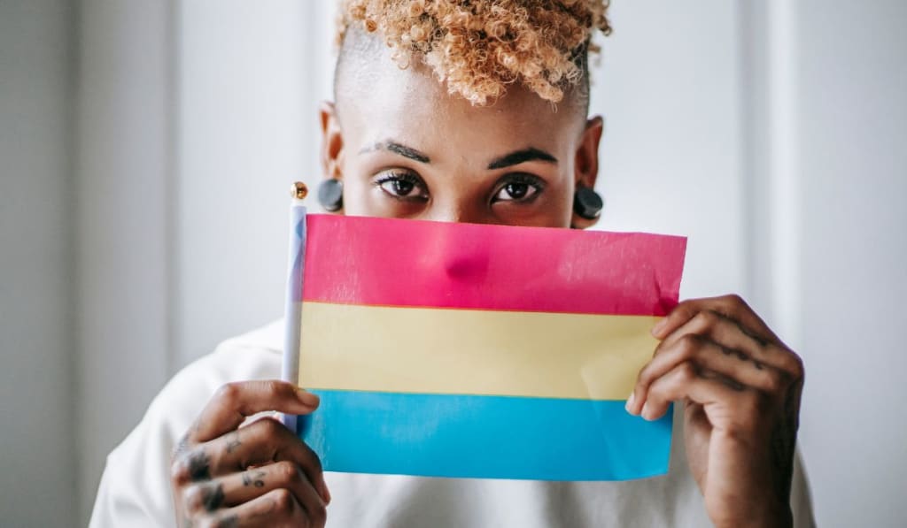 Black tattooed woman showing Pansexual pride flag