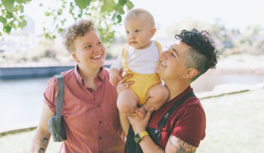 Happy Couple with Their Baby at the Park