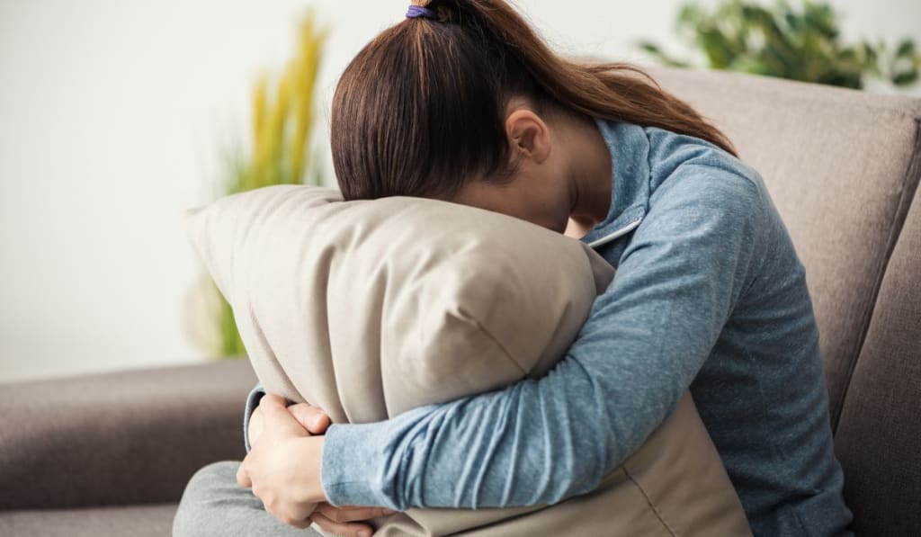 Sad woman hugging a pillow