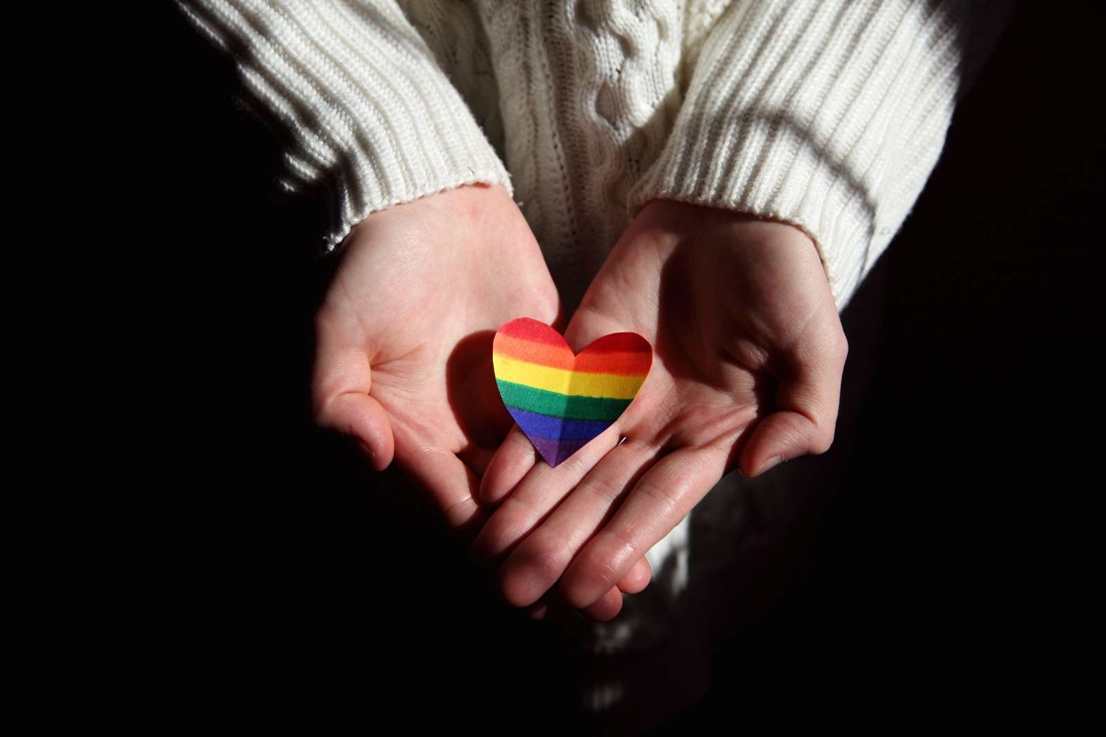 hands together with the LGBT flag