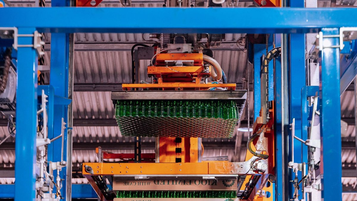 Glass manufacturing process at a factory in Dar es Salaam, showcasing automated machinery.