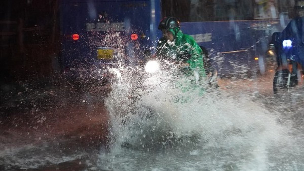 A motorcyclist struggles to make his way through floodwaters during heavy rain on Tran Xuan Soan Street in Ho Chi Minh City o