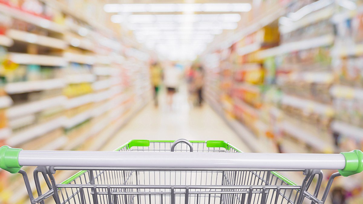 U.S. private label share hits record Supermarket aisle with empty shopping cart at grocery store retail business concept.