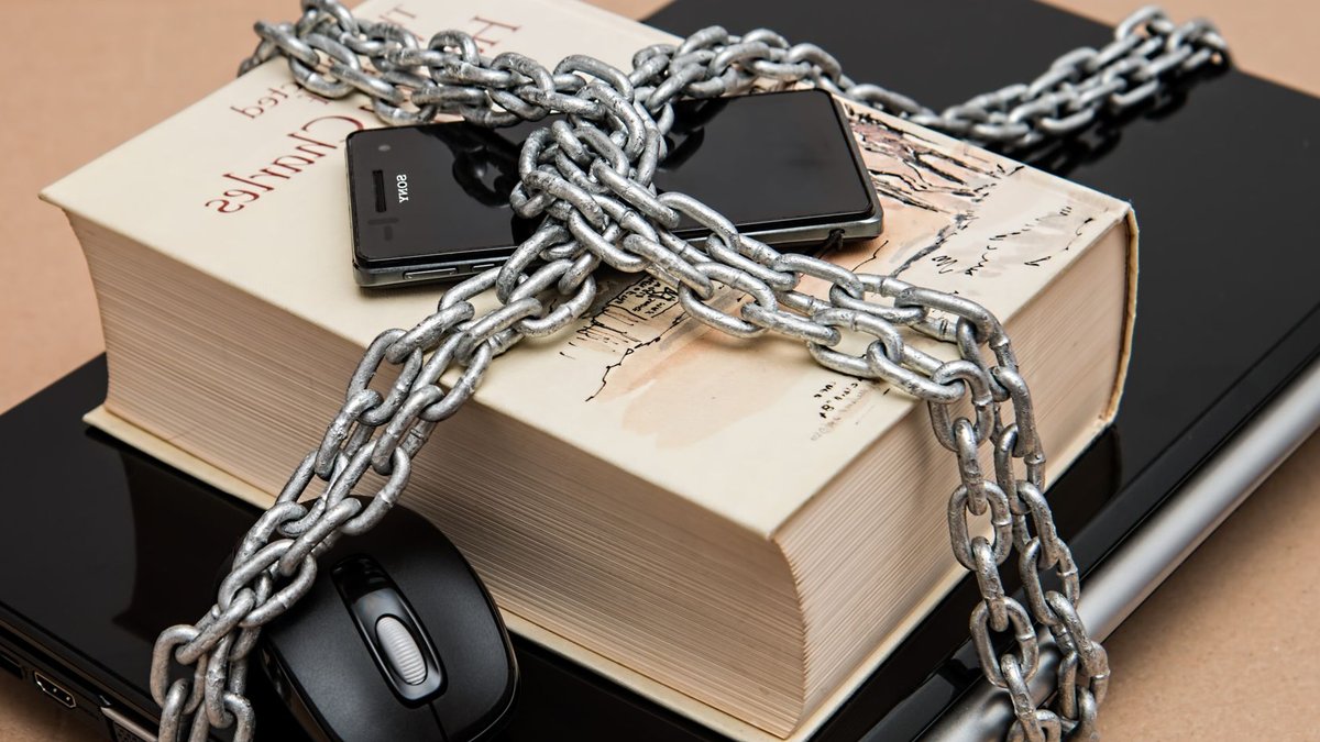 Meta fixes Muse AI flaw but leaves enterprise security blind Chain-locked book, phone, and laptop symbolizing digital and intellectual security.