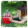 Young female toddler playing in the grass with her red Toniebox and several Peppa Pig Tonies.