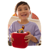Young boy with brown hair happily playing with red Toniebox 2 and Lion King character.