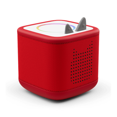 Red cubed speakerbox called the Toniebox 2  with two cute ears on top that control the sound and a magical light ring on top that lights up when a character called a Tonie is placed on top.