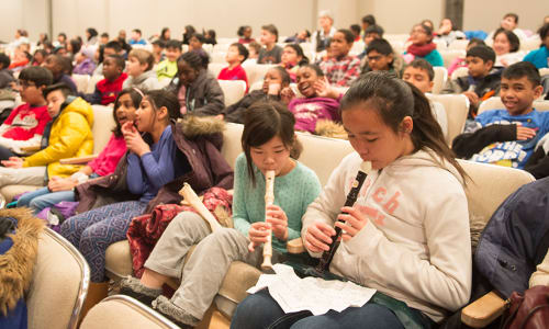 Students play their recorders at a TSO school concert