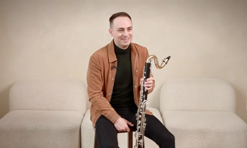 Miles Haskins sitting with their clarinet