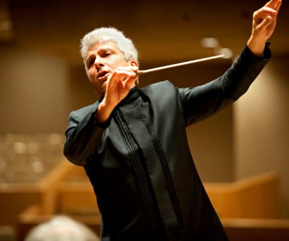 Peter Oundjian conducting with his arms raised