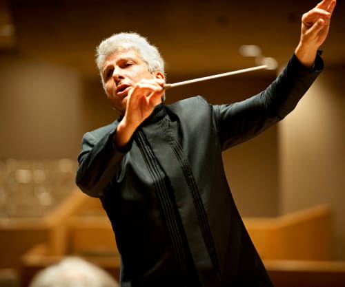 Peter Oundjian conducting with his arms raised