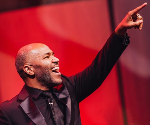 Daniel Bartholomew-Poyser smiling with his arm raised to the audience