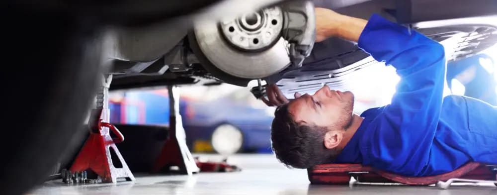 Worker servicing a car