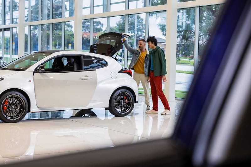 Customers inspecting a Toyota Yaris GR in a New Toyota Showroom