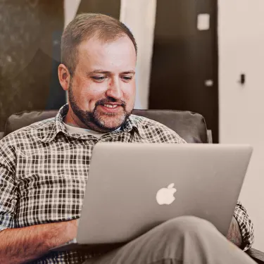 Man buying car from laptop at home