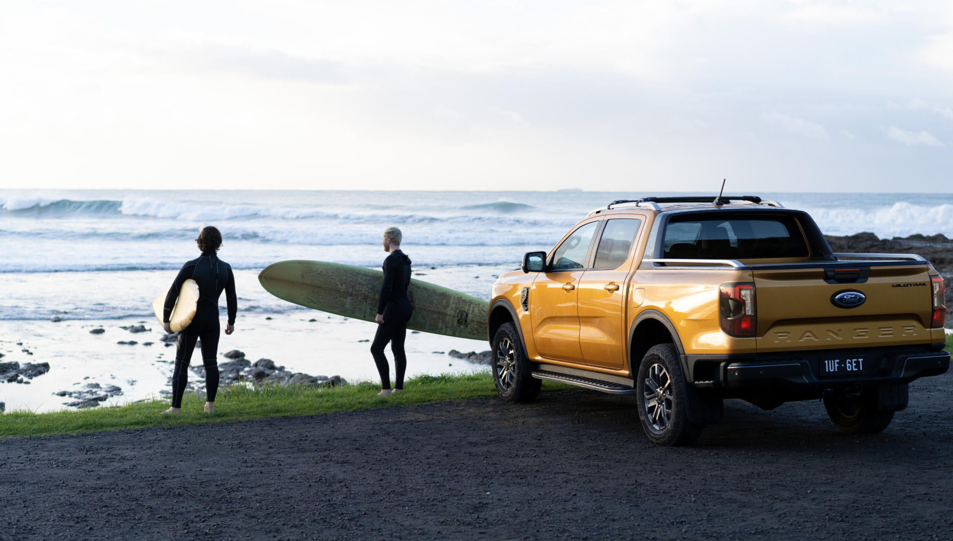 Ford on a beach with a couple of surfers