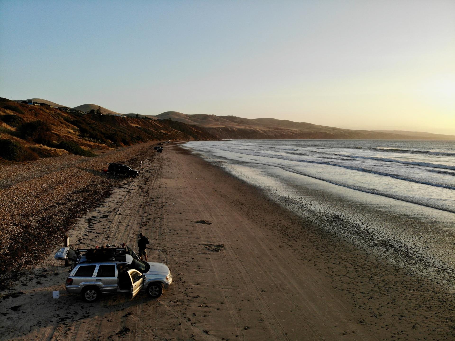 &nbsp; 4WD family vehicle parked on a sandy beach at sunset with camping gear, perfect for touring and off-road coastal adventures in Australia&nbsp;&nbsp;