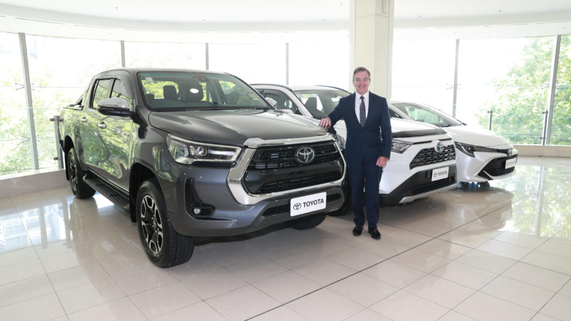 Toyota Australia President &amp; CEO Matthew Callachor with Australia’s top selling vehicle for 2021 Toyota HiLux, top selling SUV Toyota RAV4 (vehicle shown with optional extras) and top selling passenger vehicle Toyota Corolla.