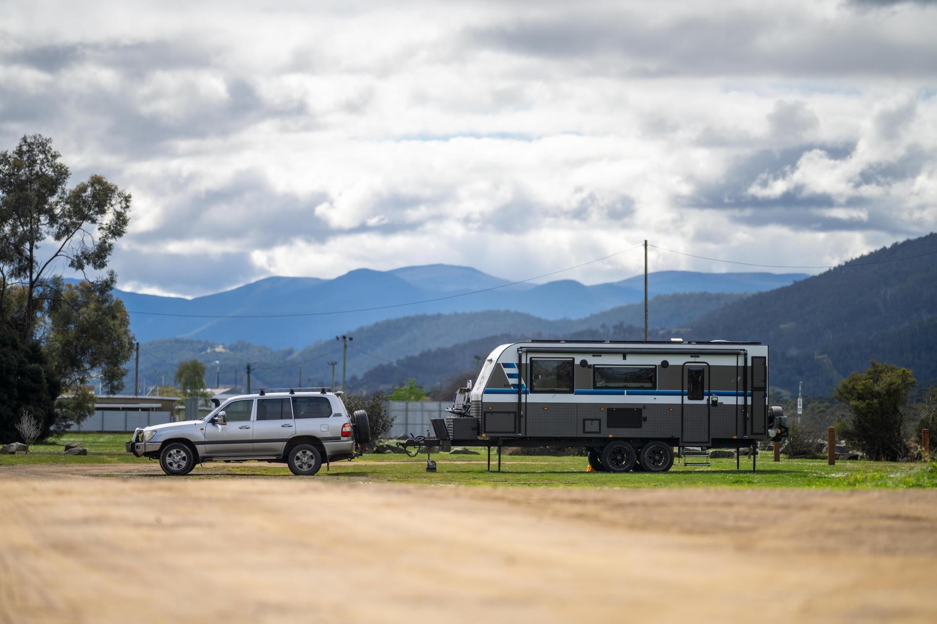 &nbsp; 4WD SUV towing a large caravan in rural Australia with mountain backdrop, showcasing towing capacity and payload for off-grid travel setups&nbsp;&nbsp;