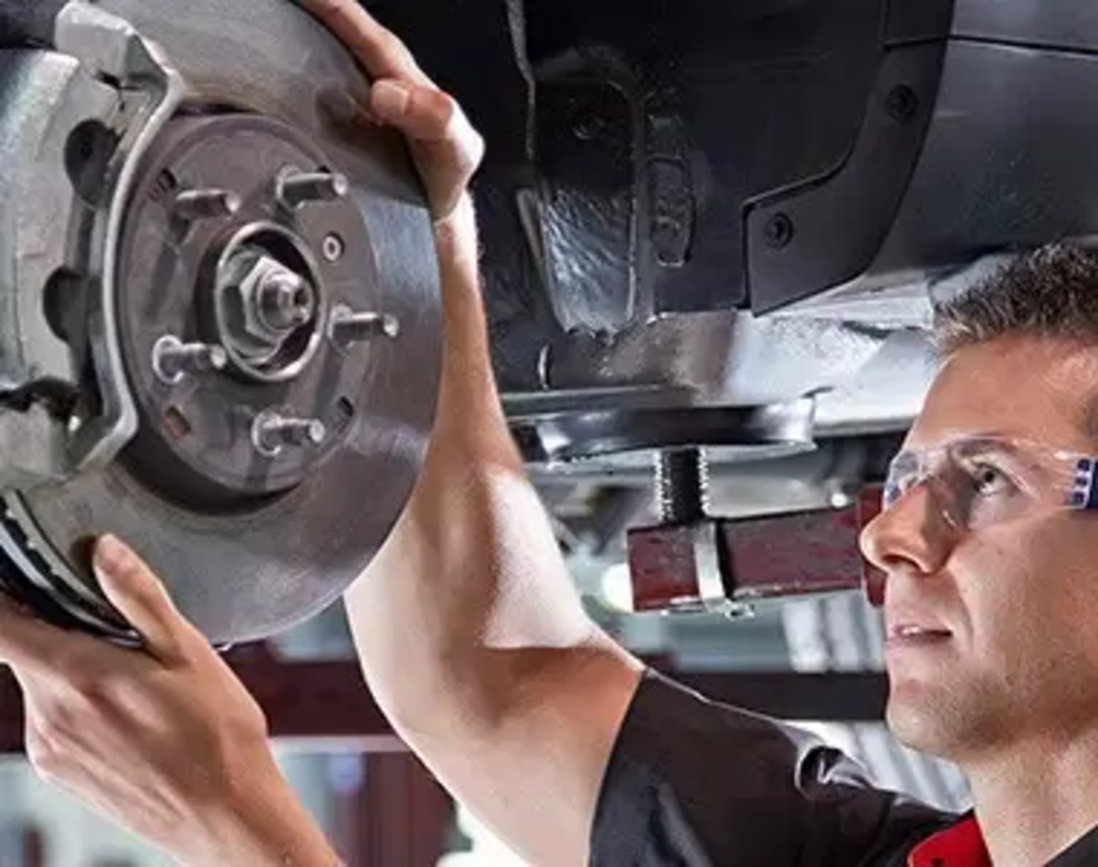 Worker fitting the hub of a car wheel into place