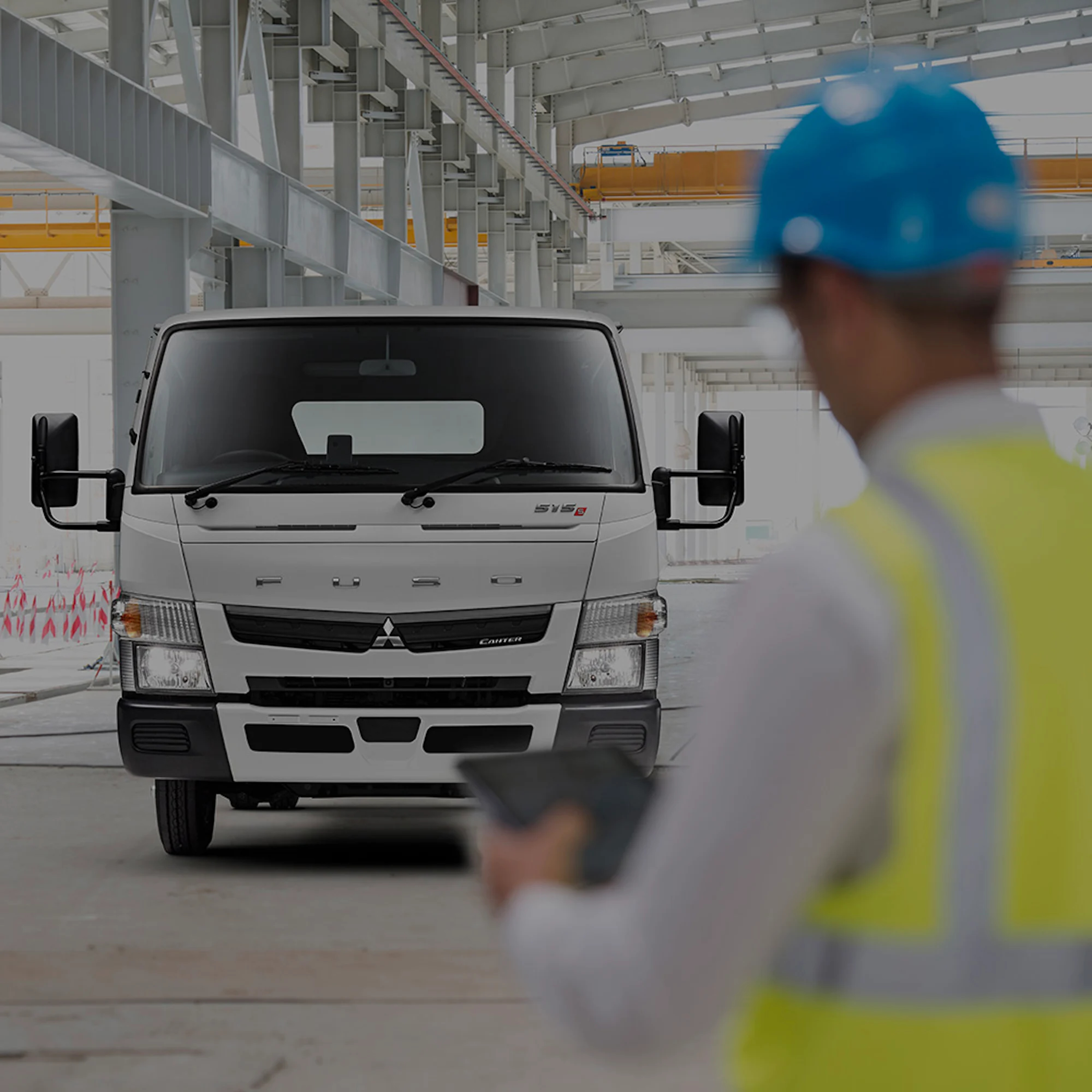 A man in high vis inspecting a Fuso truck