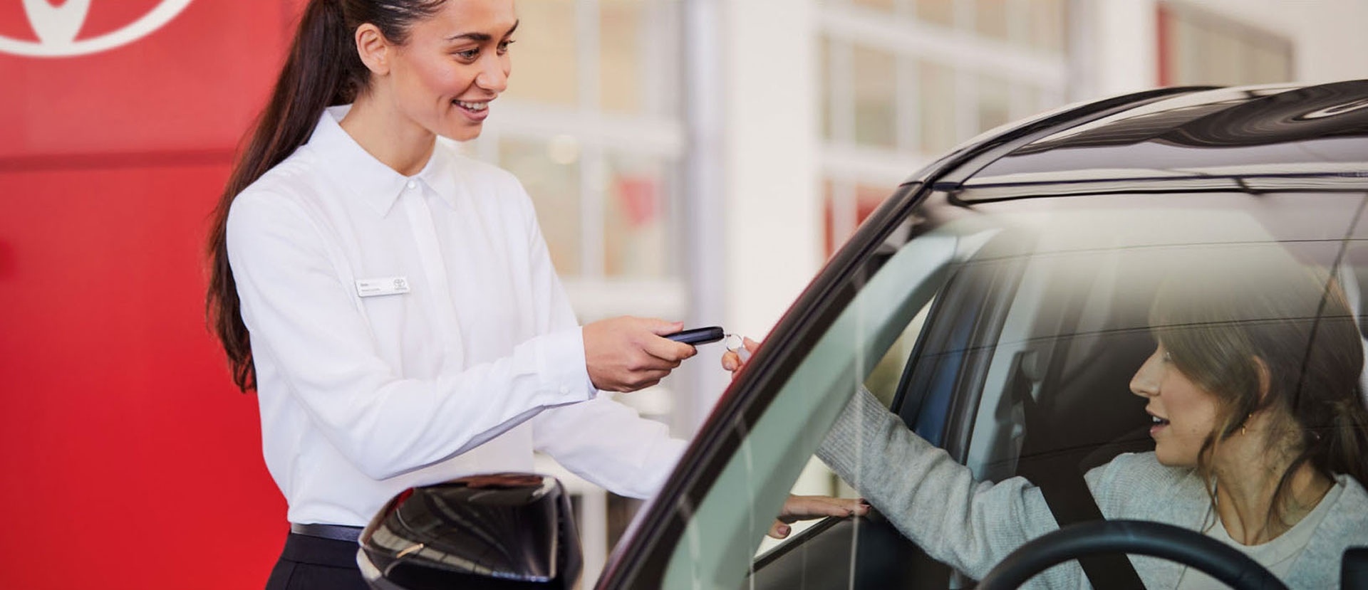 Toyota sales person giving keys to Toyota car owner