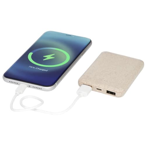 A lifestyle image of the Asama 5000mAh Wheat Straw Power Banks in Beige charging a device