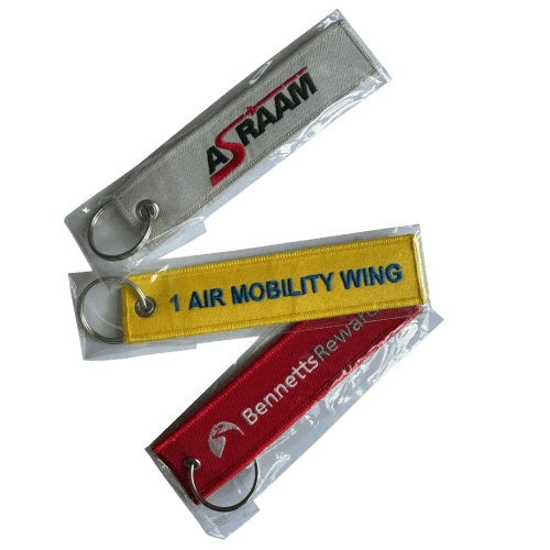 A lifestyle image of the Embroidered Keyrings shown in the plastic sleeves that they will arrive in