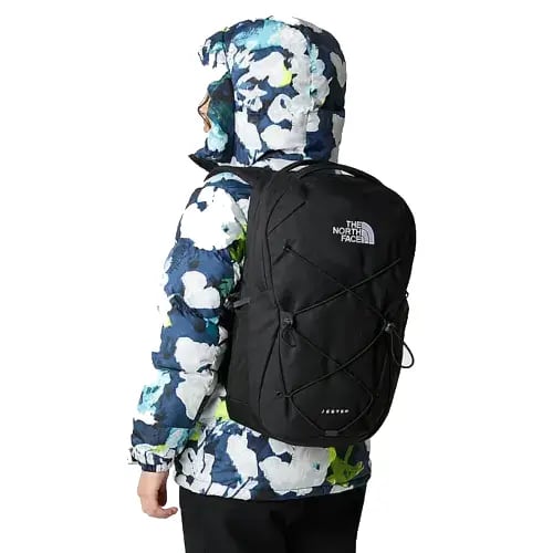 A lifestyle image of someone using The North Face Jester Backpack in Black from Total Merchandise