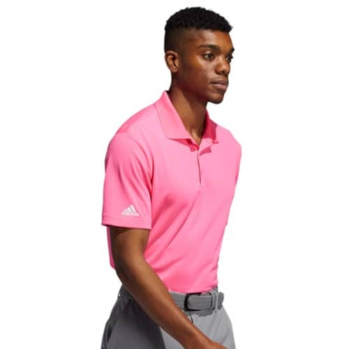 A lifestyle image of the Adidas Performance Polo Shirt in Solar Pink from Total Merchandise