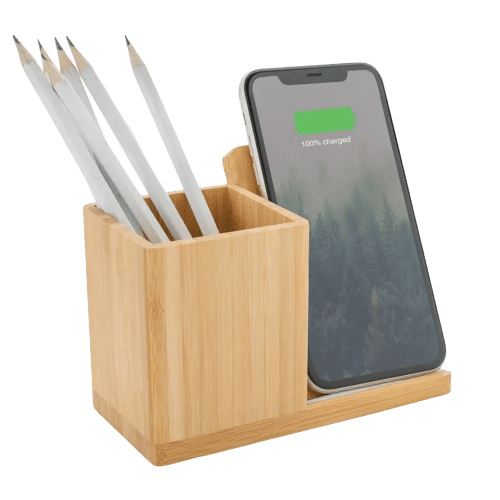 An image of the Calgary Bamboo Wireless Charger charging a device and being used as a pen pot