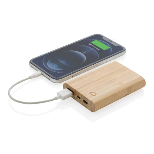 A lifestyle image of the Bamboo 5.000 mAh powerbank charging a mobile device