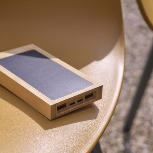 Lifestyle image of the Bamboo Solar Power Bank in Brown with your logo from Total Merchandise