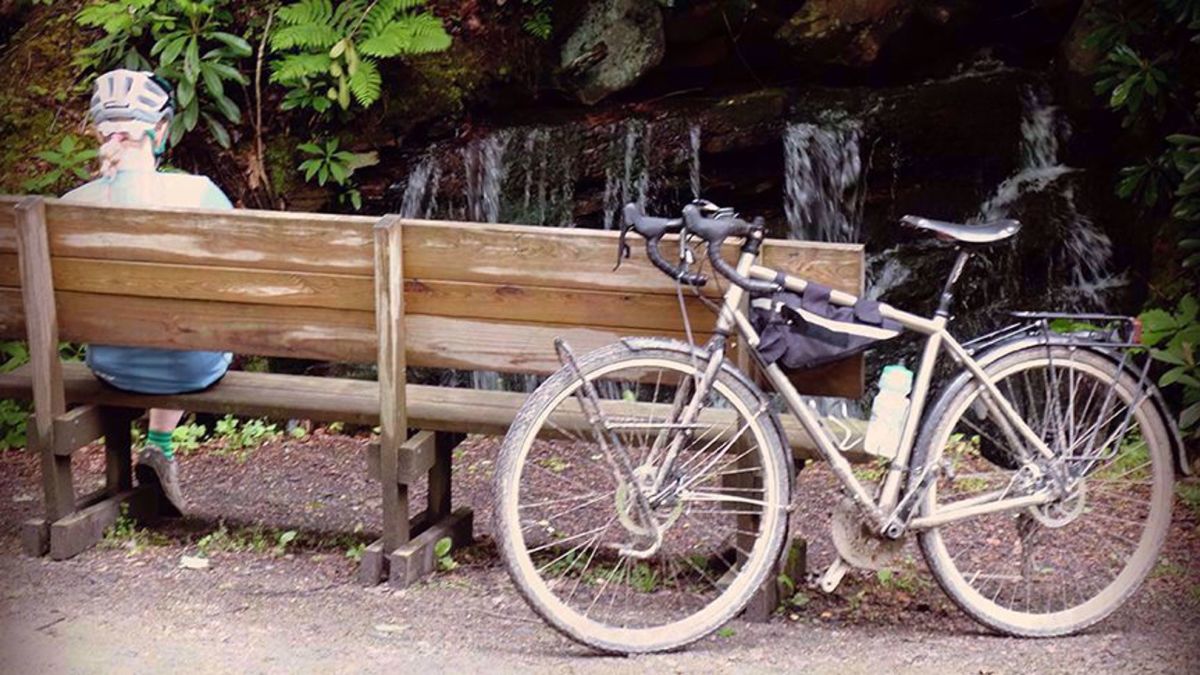 Great Allegheny Passage Bike Tour Guest sitting on a bench on the trail