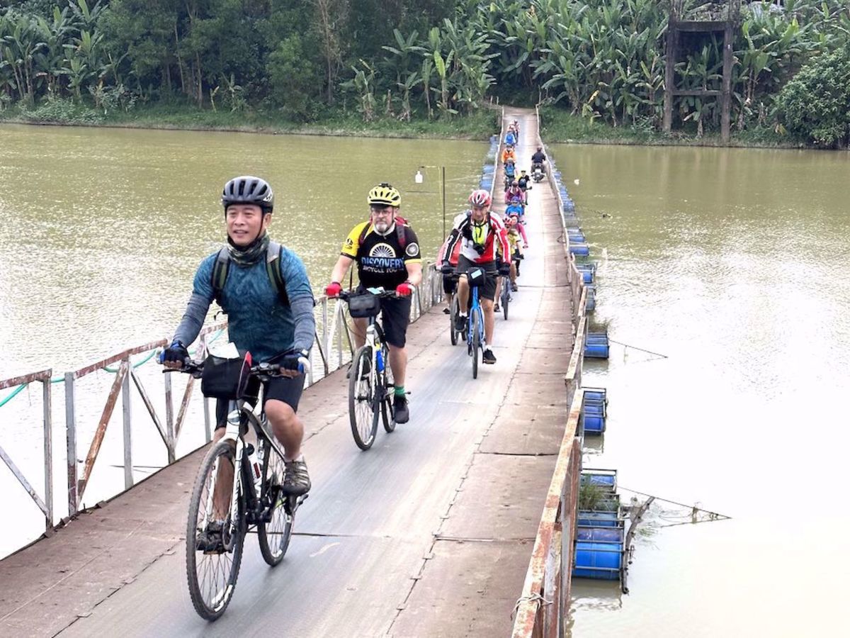 Vietnam Adventure Bike Tour Guests riding along a bridge