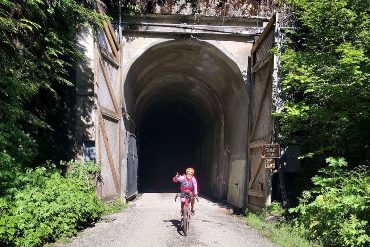 Washington Cascades Trails Bike Tour guest at the exit of a tunnel