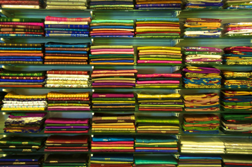 Slk sarees stacked in a shop
