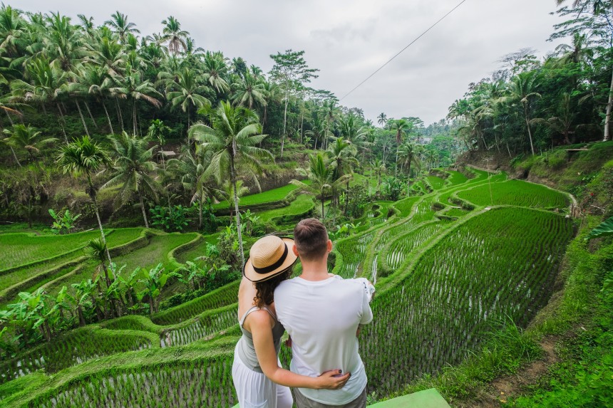 Couple enjoying the lush rice terraces of Bali.