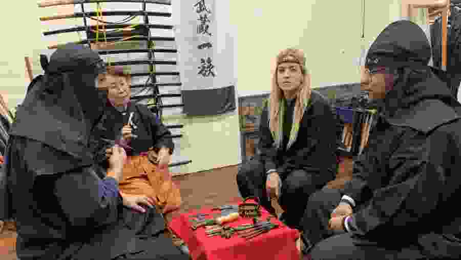 Travelers being instructed about the tools of a Ninja