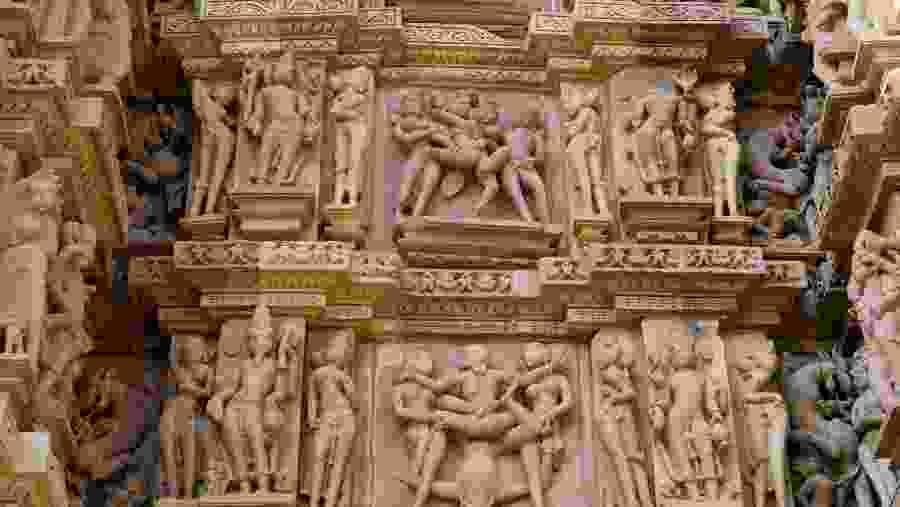 Stone carved erotic bas-relief in Hindu temple in Khajuraho, India. Unesco World Heritage Site.